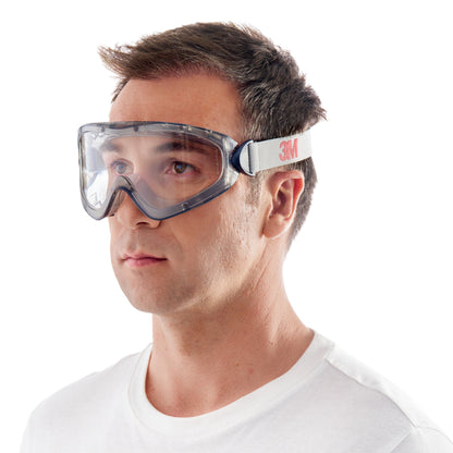 Ein Mann trägt ein weißes T-Shirt und die 3M™ Schutzbrille 2890, versiegelt, Klarsichtscheibe von 3M Deutschland GmbH - mit grauem Rahmen und weißem "3M"-Gurt - vor einem schlichten weißen Hintergrund.