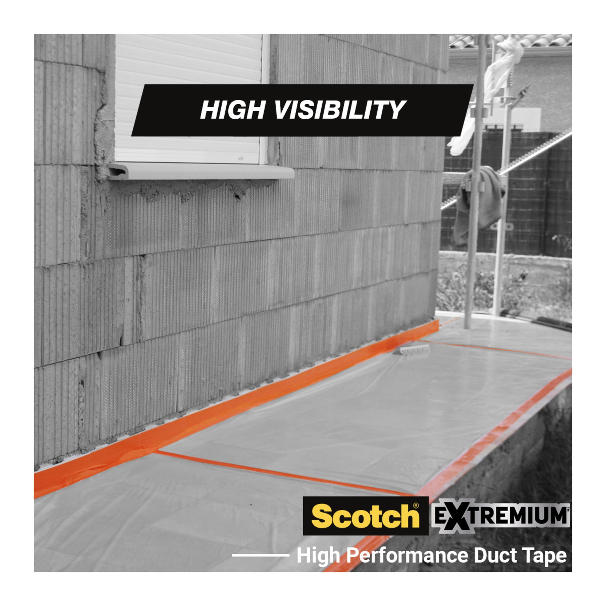 Eine Hausfassade mit einem Fenster zeigt das Scotch® High Visibility Klebeband, orange (25 m x 48 mm), von 3M, das durchsichtige Plastikfolien am Boden befestigt. Die hohe Sichtbarkeit des Bandes ist auf der Rolle mit der Aufschrift "Scotch® High Visibility" angegeben.