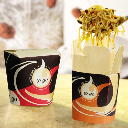 Two Starpak 50 snack boxes "To Go" square – 550 ml stand on a light surface; one is closed, the other open, and noodles are being lifted out with a fork. The blurred background emphasizes the practical design for takeout.