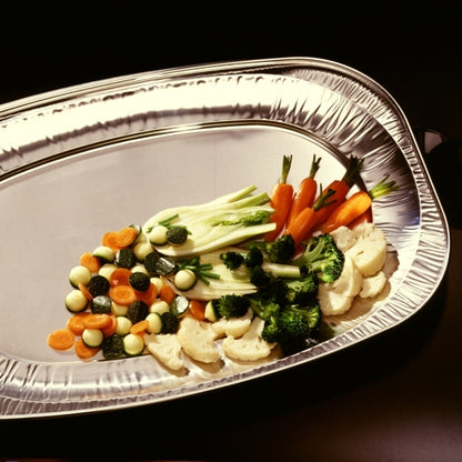 The Starpak 3 serving plates, aluminum from Starpak, offer space for a selection of steamed vegetables - baby carrots, broccoli, zucchini, cauliflower, and fennel - beautifully arranged for elegant presentations against a dark background.