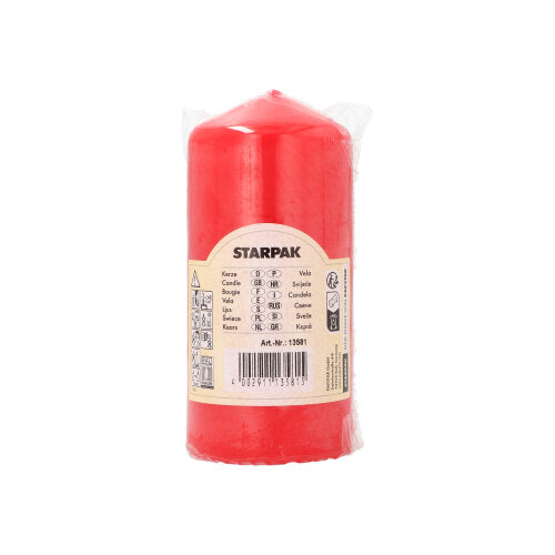 A red Starpak pillar candle with extra long burning time (Ø 60 mm, 130 mm) is wrapped in transparent foil and provided with a beige label displaying product details, barcode, and application symbols. The brand “Starpak” is highlighted on the label.