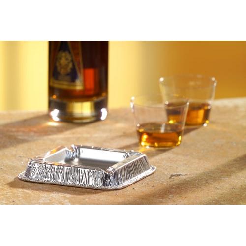 A compact, square Starpak 10 ashtray (aluminum, 2.2 cm x 12.5 cm x 12.5 cm) sits on a countertop next to two glasses of amber liquid – practical smoking accessory for any room, available as a set of 10 in shrink wrap.