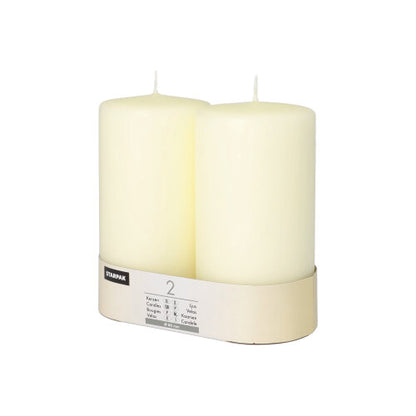 Two Starpak pillar candles Ø 80 mm with flat top stand in a simple cardboard holder with a label – a touch of timeless elegance for any ambiance.