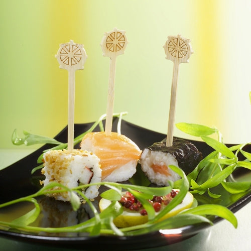 Three sushi pieces on a black plate, each uniquely topped and secured with the PAPSTAR finger food pick "Steering Wheel" 9 cm from PAPSTAR GmbH, are perfect for parties. Green garnish and red sauce adorn the dish and offer stylish catering with the cardboard tray (200 pieces).