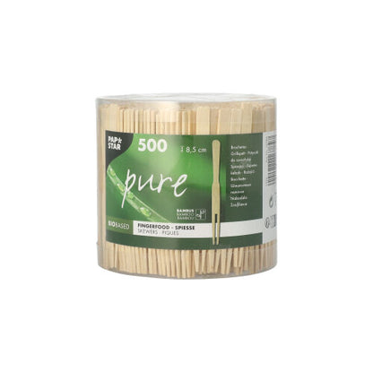 The transparent plastic container from PAPSTAR GmbH holds 500 "finger food skewers pure" (8.5 cm), perfect for snacks. The green-white "pure" label shows product info and branding - ideal wooden skewers for your party accessory needs.