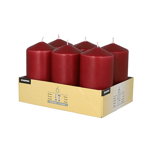 A cardboard tray holds six large Starpak pillar candles (Ø 60 x 115 mm) made from high-quality wax with long burning time in two rows of three, packaged with product details and the Starpak brand name.