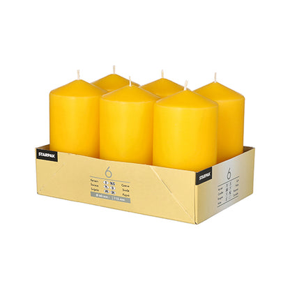Six Starpak pillar candles (Ø 60 mm · 115 mm) made from high-quality wax offer a long burning time. The yellow candles stand neatly in a light brown cardboard with labels, have a cylindrical shape, flat tops, and visible wicks.