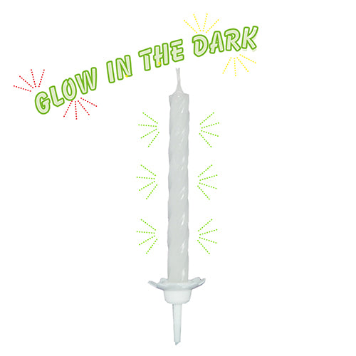 A PAPSTAR candle with holder 6 cm, Glow in the Dark (10 pieces, PAPSTAR GmbH) stands upright. Above it, the neon green "Glow in the Dark" lettering is highlighted with colorful starburst accents.