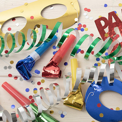 Party items such as PAPSTAR GmbH face masks "Metallic" assorted colors (pouch, 6 pieces), colorful noisemakers, streamers, confetti, and a "PARTY" sign are scattered on a bright wooden surface - perfect for your celebration!.