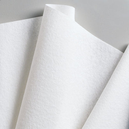 Close-up of overlapping Kimberly-Clark GmbH WypAll® L40 PowerClean quarter-folded paper towels (white, 18 packs x 56 sheets), arranged at an angle against a neutral background.