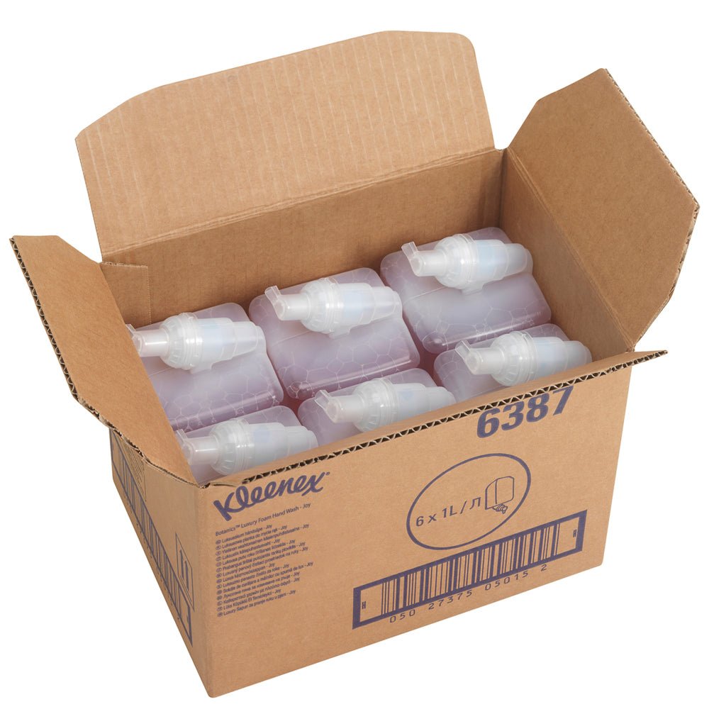 An open box labeled "Kleenex® Botanics™ Luxury Foam Hand Wash" from Kimberly-Clark GmbH contains six red 1-liter refill cassettes (cartridges). The box displays a barcode and the product number 6387.