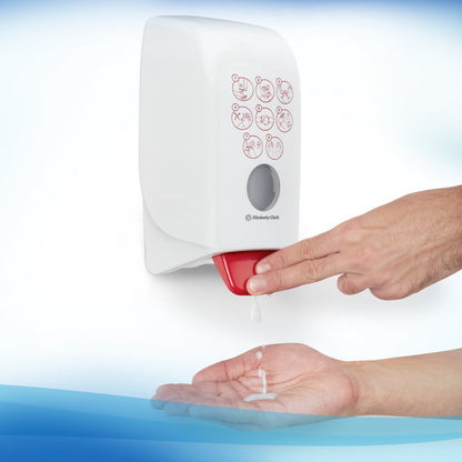 The user presses the lever of the Scott® CONTROL alcohol-based hand sanitizer foam (1L cartridge) from Kimberly-Clark GmbH and dispenses the foam onto their hand. Symbols for hand hygiene are displayed on the front of the transparent wall unit.