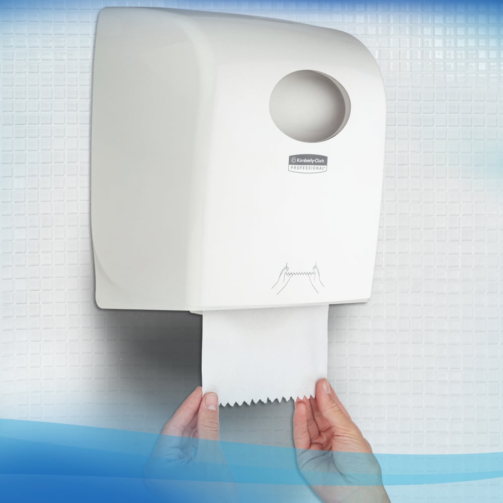 A person pulls a Scott® Control™ towel - roll / white from a white wall dispenser by Kimberly-Clark GmbH in a restroom with tiled walls, ensuring hygienic hand drying.