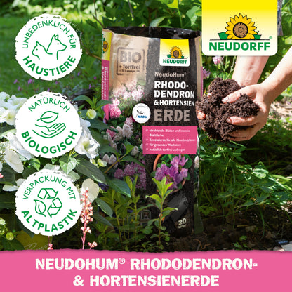 Eine Person mit reichhaltiger NeudoHum Rhododendron & Hortensien Erde aus dem Neudorff Shop, ideal zur Förderung des gesunden Wachstums von Rhododendron.
