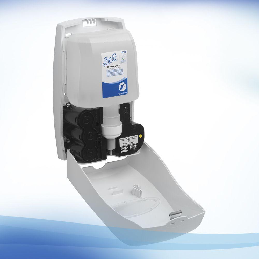 A wall-mounted soap dispenser with an open front shows a Scott® Control™ Foam Hand Cleanser refill from Kimberly-Clark GmbH. It is depicted against a white-blue gradient background and is ideal for hand hygiene protocols. The box contains 4 cartridges.
