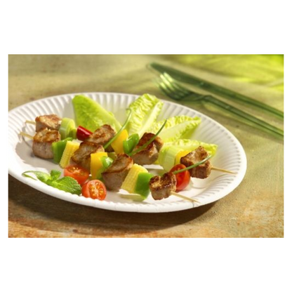 A 29 50 Plate, cardboard "pure" round - white from PAPSTAR GmbH holds skewers with sausage, cheese, cucumber, and tomato on lettuce; in the background, green utensils provide an eco-friendly touch.