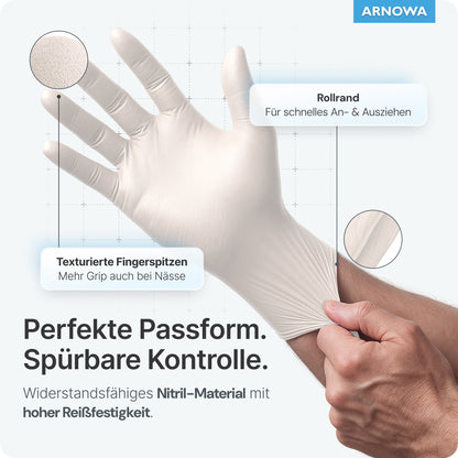 Ein Benutzer zieht ARNOMED NITRIL WHITE Reißfeste Einmalhandschuhe von ARNOWA GmbH an, indem er an der gerollten Stulpe zieht. Etiketten zeigen strukturierte Fingerspitzen und betonen sein latexfreies Design, starken Grip und reißfestes Material.
