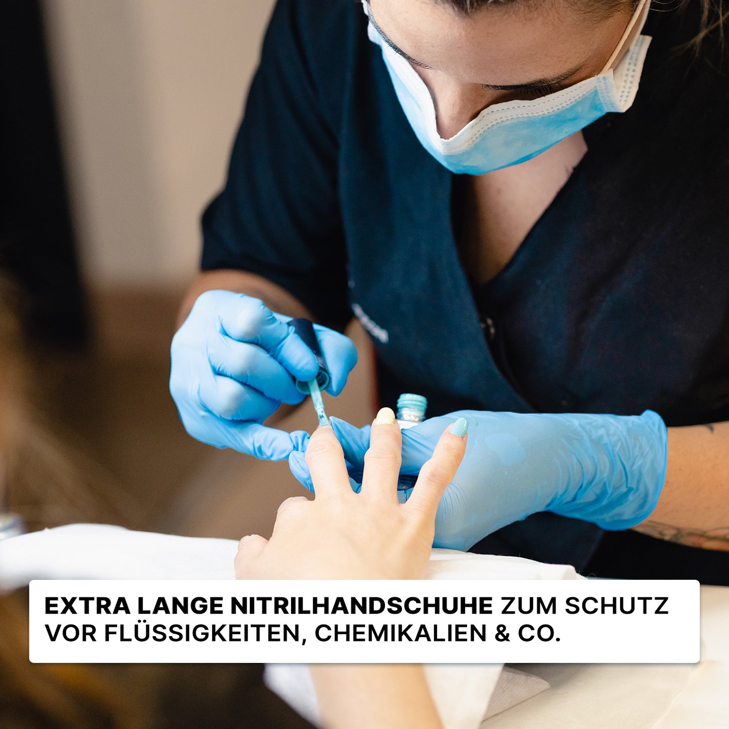 A person wearing ARNOMED NITRIL BLUE XTRA LONG (30 cm) disposable gloves from ARNOWA GmbH and a mask is painting someone's nails; German text emphasizes the protective function of the blue nitrile gloves.