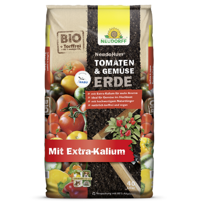 Ein 40L-Sack Neudorff Shop NeudoHum Tomaten- & GemüseErde, torffrei und vegan mit extra Kalium, ideal für Sommergemüse. Bio-Verpackung mit Tomaten, verschiedenen Gemüsesorten, Erde und Pflanzenblättern.