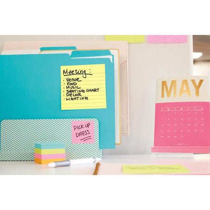 A workspace with 3M Deutschland GmbH Post-it® Notes in large format, Yellow (101 mm x 152 mm), file folders, a rose-gold desk calendar for May 2017, as well as colorful sticky notes and papers. One note lists "Meeting" topics, another says "PICK UP DRESS."