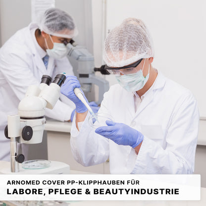 Two people in a lab wear ARNOMED COVER PP CLIP CAP disposable clip caps (52cm, ARNOWA GmbH). The caps made of PP fleece offer optimal hygiene protection for laboratory technology as well as care and beauty industries.