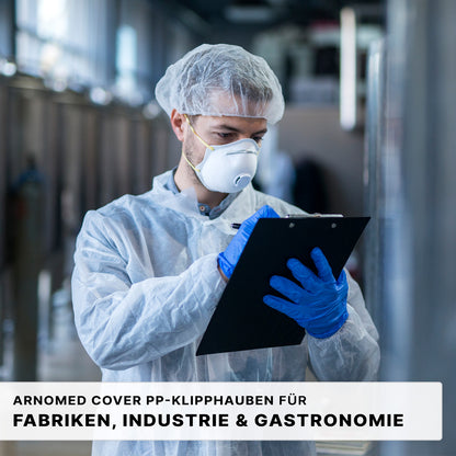 A person with a protective gown, ARNOMED COVER PP CLIP CAP (52cm, ARNOWA GmbH), face mask, and blue gloves writes on a clipboard in an industrial/laboratory environment. The German text below advertises the hygiene protection PP fleece for factories and gastronomy.
