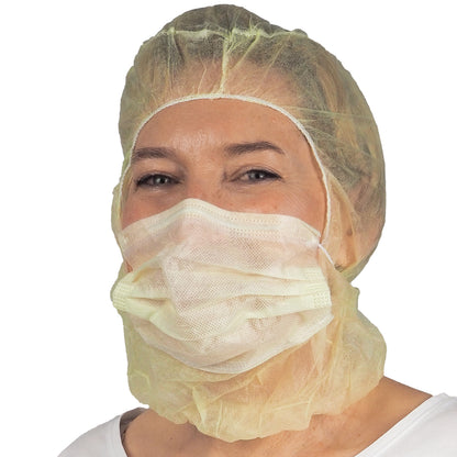 Eine Person trägt die ARNOMED COVER PP-ASTROHAUBE MIT 2-LAGIGEM MUNDSCHUTZ der ARNOWA GmbH, eine gelbe Einweghaube und eine passende zweilagige Gesichtsmaske, die Haare und Mund bedeckt, vor einem schlichten weißen Hintergrund.