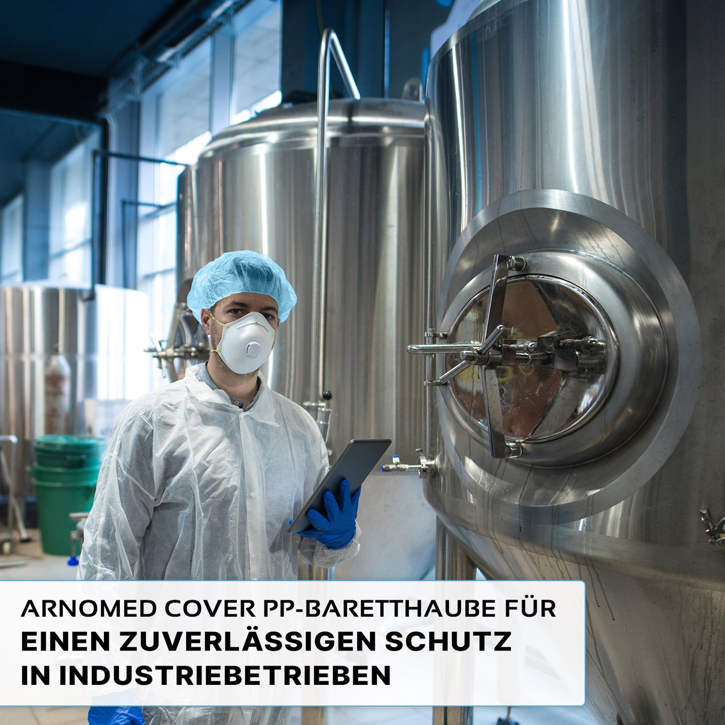A person wearing an ARNOMED COVER PP-BARETTHAUBE bouffant cap made of PP non-woven fabric by ARNOWA GmbH and a mask stands in front of stainless steel tanks in an industrial hygiene area holding a tablet. The German text highlights reliable protection for the industry.
