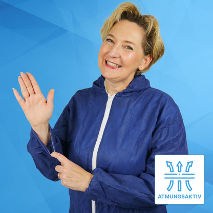 A woman in the ARNOMED COVER PP-OVERALL BLUE disposable overall with a hood made of PP fleece from ARNOWA GmbH smiles and points to the sleeve, where a "BREATHABLE" symbol highlights the breathable fabric against a blue geometric background.