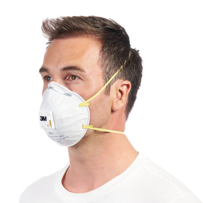 A man in a plain white shirt wears a 3M™ Cool Flow™ Particulate Respirator 8812, FFP1, with valve (3M Deutschland GmbH), in side view against a white background. The mask has yellow bands and is delivered in a 3-pack.