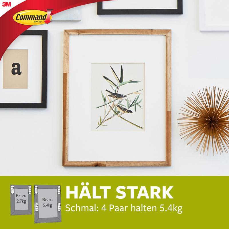 A framed botanical print hangs on a white wall with decor, including gold and framed letters. Text: "HOLDS STRONG, Narrow: 4 pairs hold 5.4kg." Narrow Command™ Picture Hanging Strips (M) 17207 from 3M Deutschland GmbH securely fix narrow frames.