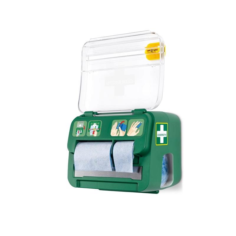 The green, wall-mounted Cederroth soft foam bandage 2-in-1 dispenser from Orkla Wound Care AB holds six bandages, has a transparent lid with a cross symbol, blue paper rolls, a pictorial guide, and a yellow tool for emergency wound care on the top.