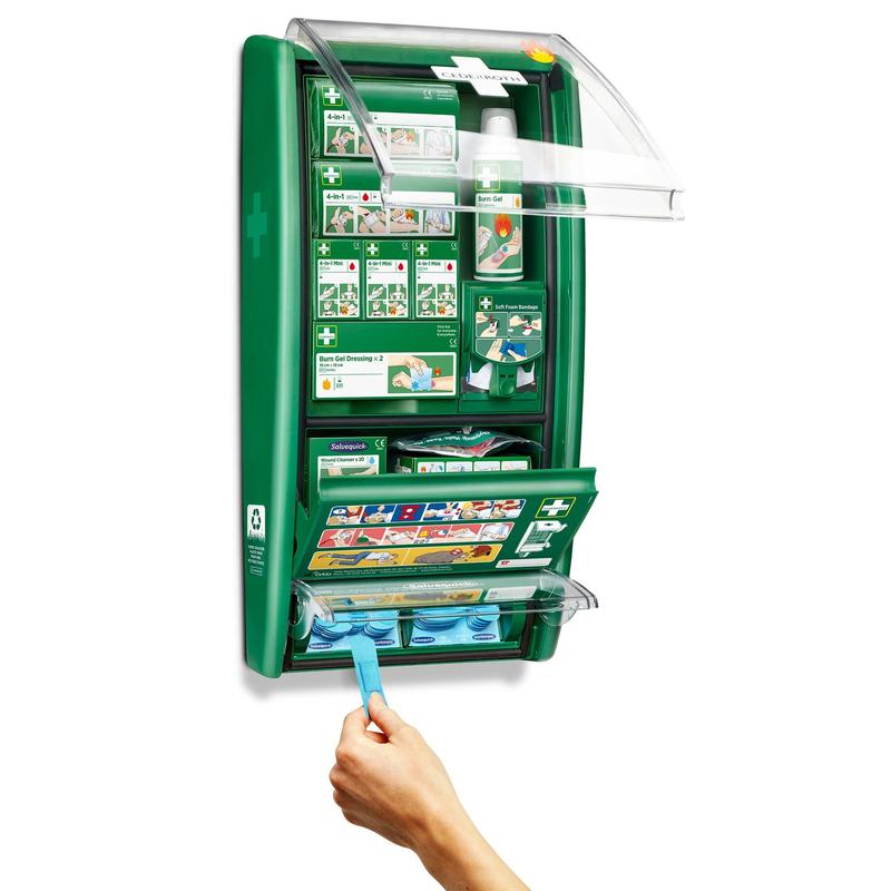 The Cederroth first aid & burn station from Orkla Wound Care AB is a green, wall-mounted set with labeled compartments for bandages, dressings, and burn gel. A hand pulls a blue cloth from the opened unit, revealing organized supplies and clear instructions.