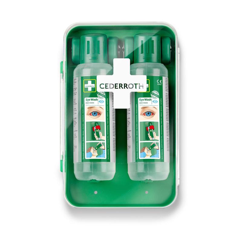The Cederroth Eye Wash Cabinet 1x1 by Orkla Wound Care AB is a green wall cabinet containing two transparent eye wash bottles with green caps, an instruction manual, and a white lid with a cross-shaped first aid kit for eye washes.