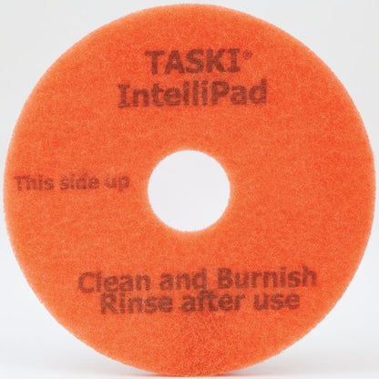 The TASKI Intellipad Combined Cleaning and Polishing Pad for maintenance cleaning from Diversey Deutschland GmbH & Co. OHG is an orange, circular pad with a hole in the center and the inscription "TASKI IntelliPad", "This side up" and "Clean and Burnish, Rinse after use" in gray lettering.
