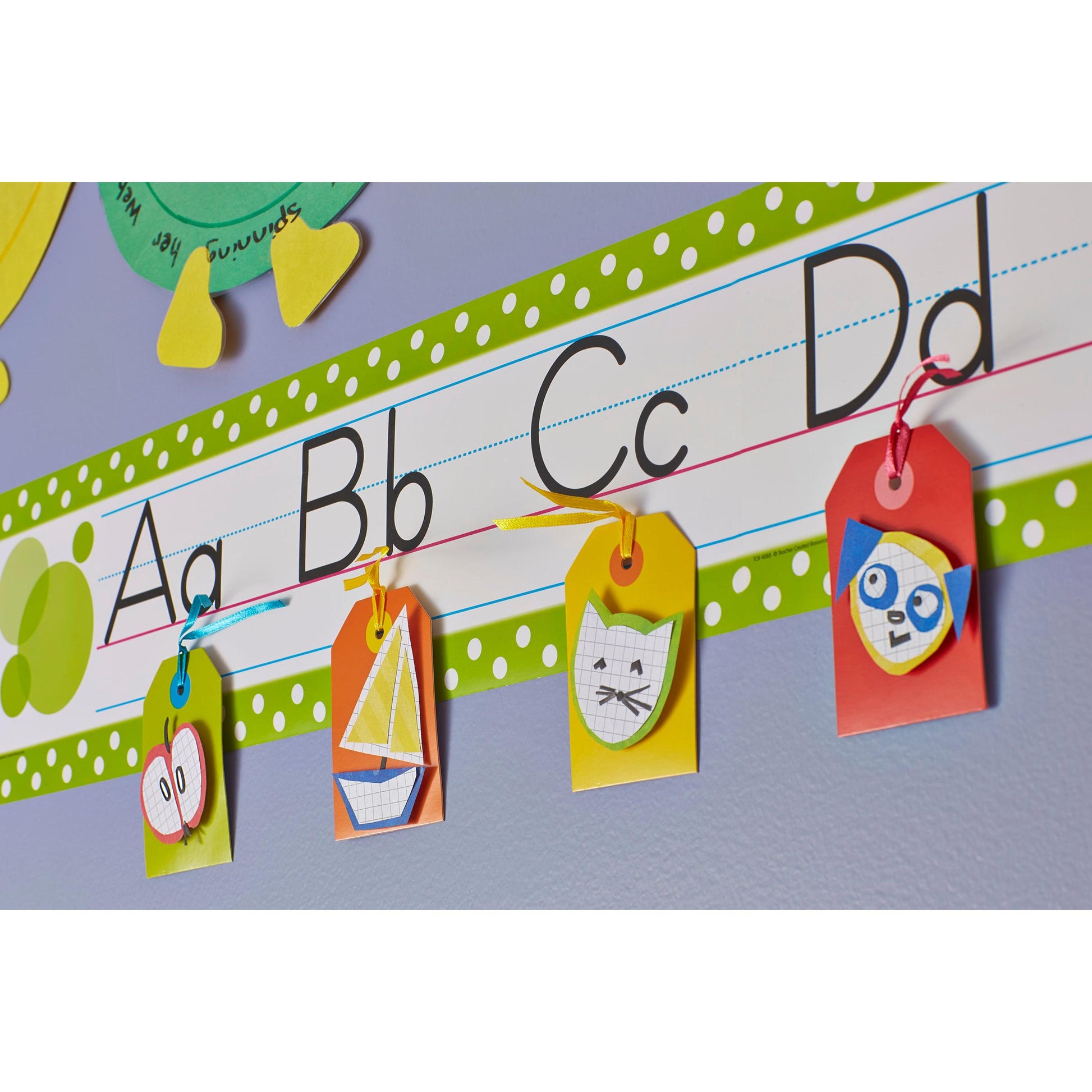 Ein Display im Klassenzimmer zeigt A, B, C und D in Groß- und Kleinbuchstaben. Vier farbige Schilder mit Zeichnungen von Schmetterlingen, Segelbooten, Katzen und Eulen werden mit 3M Scotch-FIX™ Ablösbare Klebepads (11x15 mm, 36/Packung) darunter befestigt.