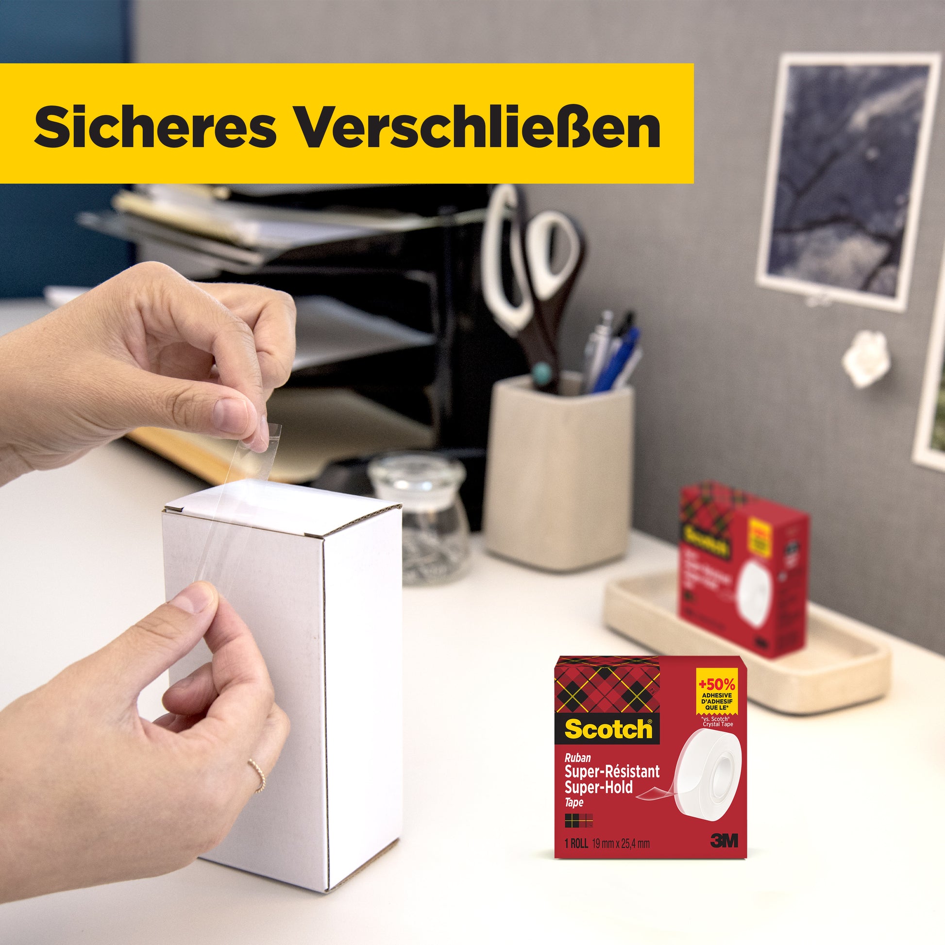 Eine Person verschließt einen weißen Karton mit 3M Deutschland GmbH Scotch® Super-Hold Secure Tape (19 mm x 25,4 m). Im Hintergrund erscheinen Büromaterialien und eine rote Rolle desselben Klebebandes mit gelber Schrift: "Sicheres Verschließen".