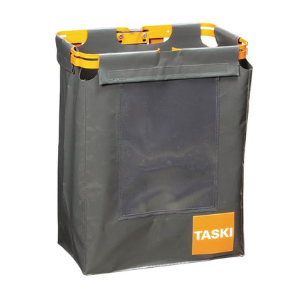 The TASKI oversack for garbage bags from Diversey Deutschland GmbH & Co. OHG is a rectangular, dark gray fabric container with orange handles, an orange frame, a transparent front pocket, and a TASKI label - perfect for hygienic waste disposal.
