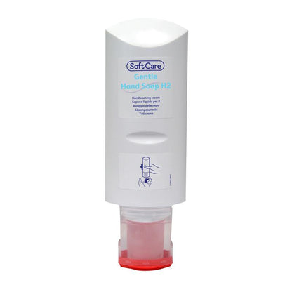 An upright, white Soft Care hand soap dispenser from Diversey Deutschland GmbH & Co. OHG with a red base. The label shows the product name, gentle cleaning instructions, and a blue line drawing of a hand using the dispenser.