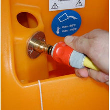 A hand connects a hose with a red and gray connector to a metal fitting on an orange TASKI swingo 2100 ?icro AquaStop from Diversey Deutschland GmbH & Co. OHG. A blue sticker nearby shows a maximum temperature of 60°C/140°F.