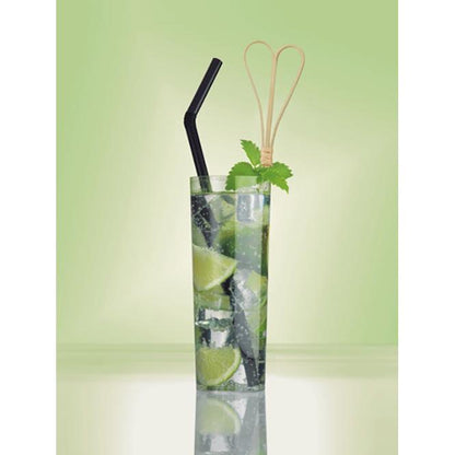 A tall glass of sparkling water with ice, lime wedges, and mint leaves is equipped with two black straws and a PAPSTAR GmbH 100 Fingerfood-Pick with a loop top. The background is a gentle green gradient.