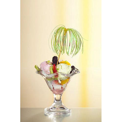 A glass dessert bowl with ice cream, various fruits, and berries is garnished with a decoration pick PAPSTAR 100 from PAPSTAR GmbH and stands in front of a gently yellow-lit background - perfect for stylish presentations.