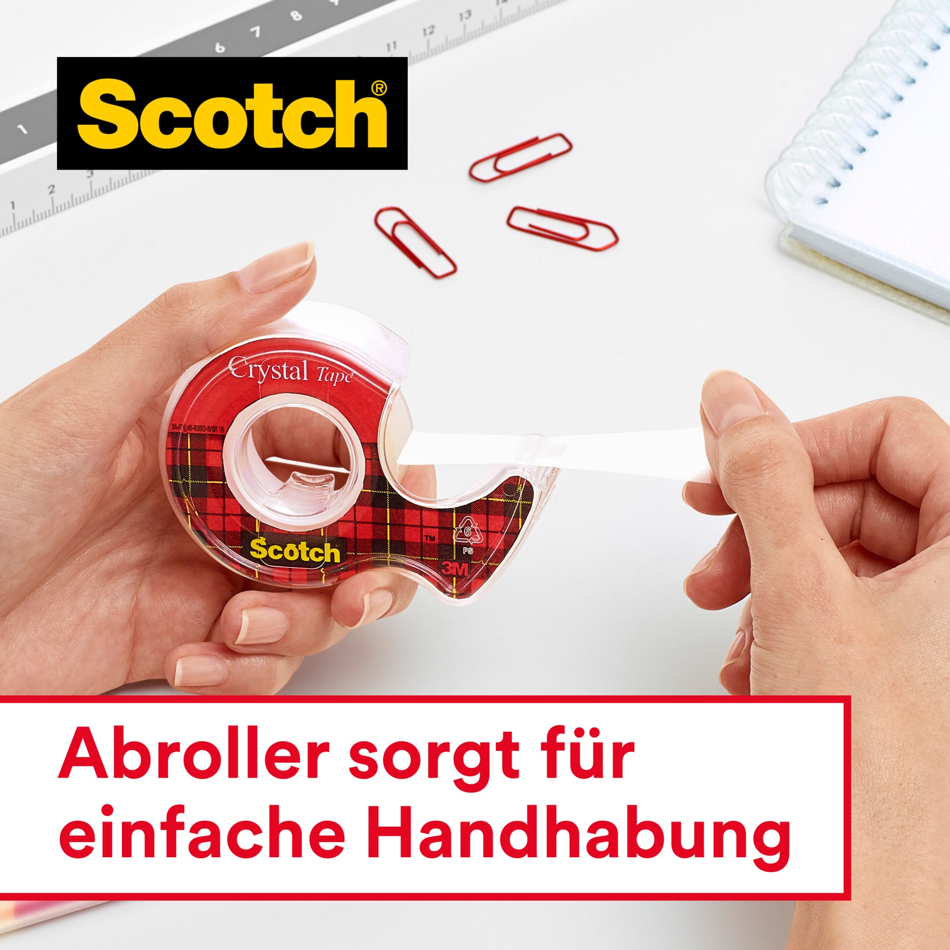 Eine Hand zieht einen Streifen transparentes Scotch® Crystal Klebeband aus einem Tartan-Spender, daneben liegen rote Büroklammern, ein Notizbuch und ein Lineal. Deutscher Text: "Abroller sorgt für einfache Handhabung." Produkt von 3M Deutschland GmbH. Vorteilspack: 8 Rollen.