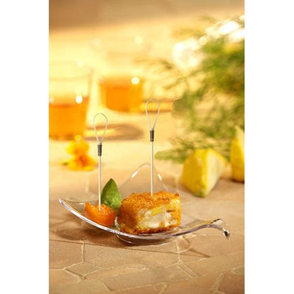 Close-up of an appetizer plate with two bite-sized snacks on PAPSTAR 100 Fingerfood - Picks from PAPSTAR GmbH, made of bamboo, garnished with fruits, on a beige surface with drinks and herbs in the background.