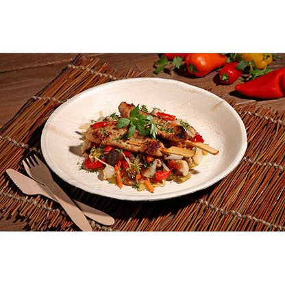 Grilled chicken skewers with a colorful vegetable pan are served on a PAPSTAR 6 plate, palm leaf "pure" round by PAPSTAR GmbH - environmentally friendly tableware, stylishly presented on a woven mat with wooden cutlery and fresh bell peppers in view.