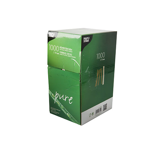 A green-white box with PAPSTAR 1000 wooden stir sticks "pure", individually wrapped from PAPSTAR GmbH, environmentally friendly, with product information and branding visible on the packaging. Contains 1,000 pieces.