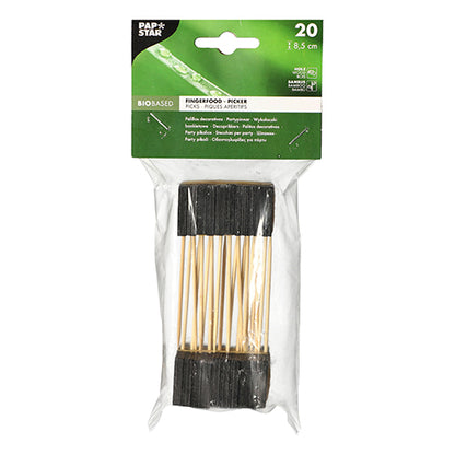 A transparent plastic package contains 20 PAPSTAR finger food picks, 8.5 cm, black - ideal for buffets and parties. The top label shows product details on a green background with white text. Brand: PAPSTAR GmbH.