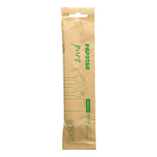 A sealed brown paper package from PAPSTAR GmbH labeled "pure" contains the environmentally friendly PAPSTAR cutlery set wood: knife, fork, spoon, and paper napkin. Green pictograms/text on the packaging indicate the environmentally friendly cutlery set.