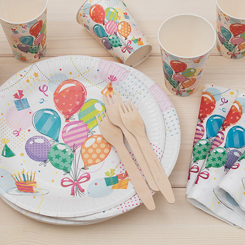 PAPSTAR 50 plates, round cardboard Ø 23 cm by PAPSTAR GmbH, along with cups and napkins with balloon and gift motifs, as well as wooden forks and knives, arranged on light wood for an eco-friendly celebration.
