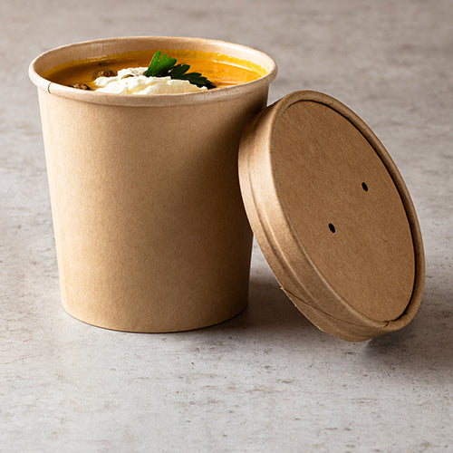 The Starpak 25 soup cup, round cardboard Ø 11.5 cm brown from Starpak is filled with orange soup, cream, and parsley – perfect for enjoying your soup dishes on the go on a light gray surface, the lid rests next to the cup.